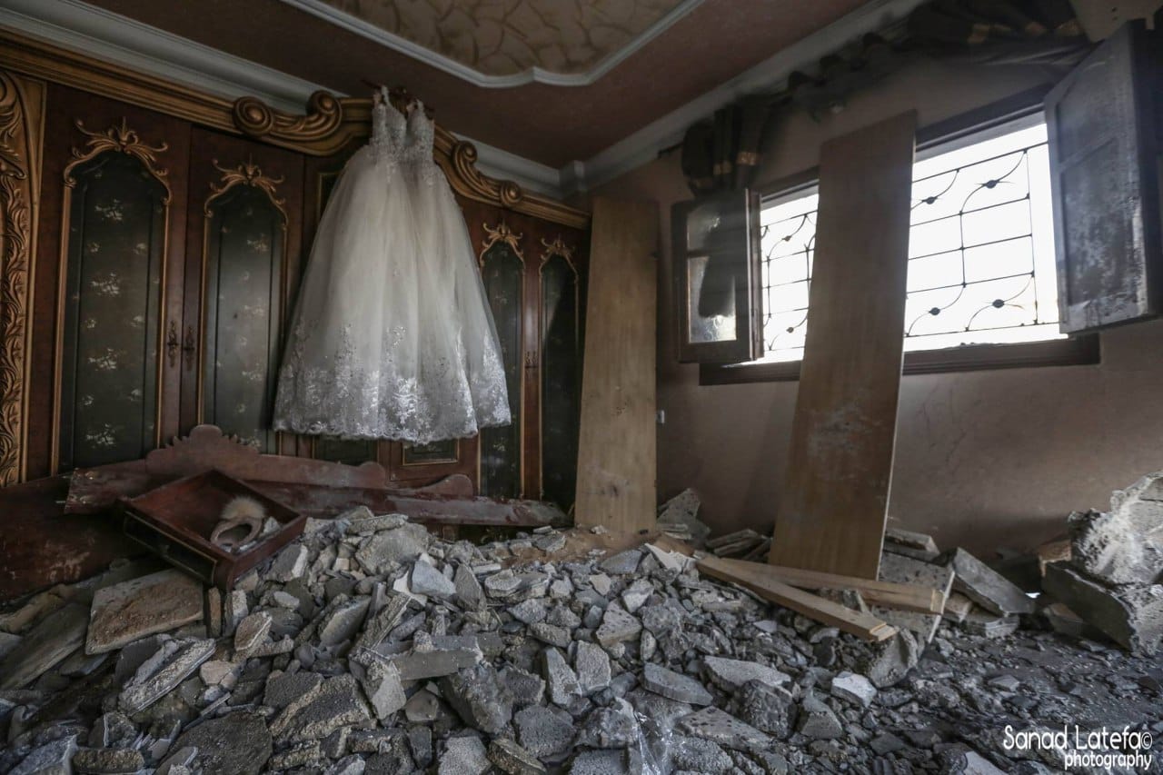 العروس سورية والعريس فلسطيني والزفاف كان مقرراً بعد أيام! لقطة مؤثرة لفستان أبيض معلق وسط منزل قصفه الإحتلال في غزة