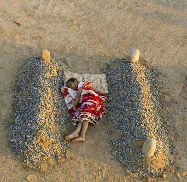 طفل سوري يرقد بين قبرَي والديه.. هذه حقيقة الصورة التي &laquo;أبكت العالم&raquo;!!