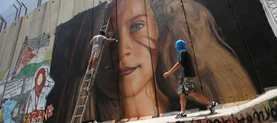 يبدو أن صورة عهد تزعج الإحتلال... رسامان إيطاليان رسما صورة &quot;الإيقونة الفلسطينية&quot; على جدار الفصل.. فاعتقلا &quot;بتهمة التخريب&quot;!