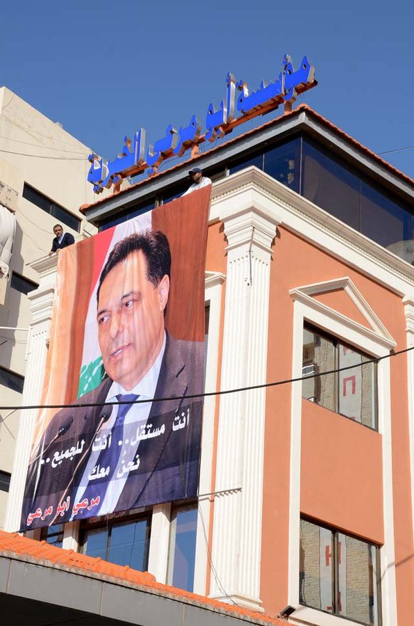 بالفيديو/ ازالة صورة الرئيس المكلف حسان دياب عن احد المباني في صيدا... لم يُعرف من رفعها