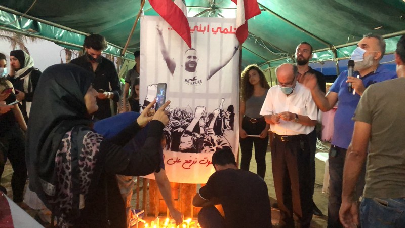 إضاءة شموع في ساحة العلم في صور تحية لروح عبد الكريم عباس