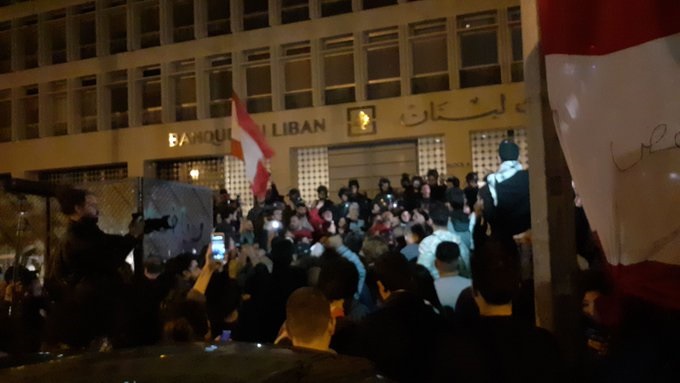 محتجون يجتازون العوائق الموجودة أمام مصرف لبنان في الحمرا بظل تواجد عناصر من ​مكافحة الشغب