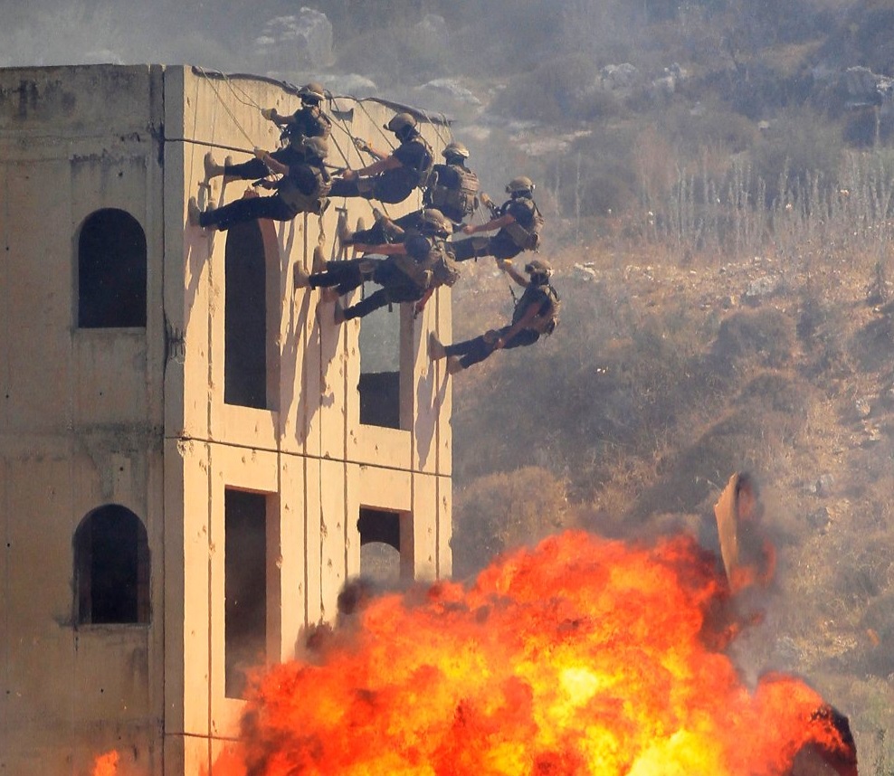 وكالة الصحافة الفرنسية تنشر صورة من المناورة التي أجراها الجيش الللبناني في كفرفالوس..&quot;يتسلقون الجدار والنيران من ورائهم&quot;!