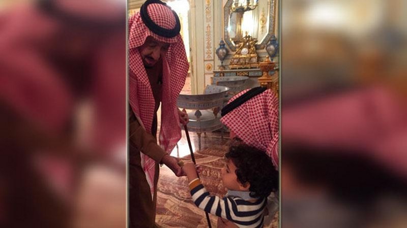 بالصورة: الملك سلمان يقدم الحلوى لطفل..هذه عادته